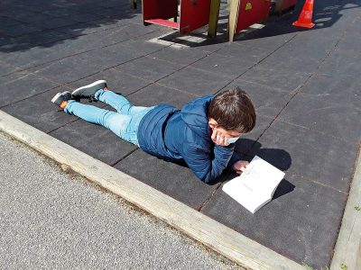 Enfant s'adonnant à la lecture sur l'aire de jeux
